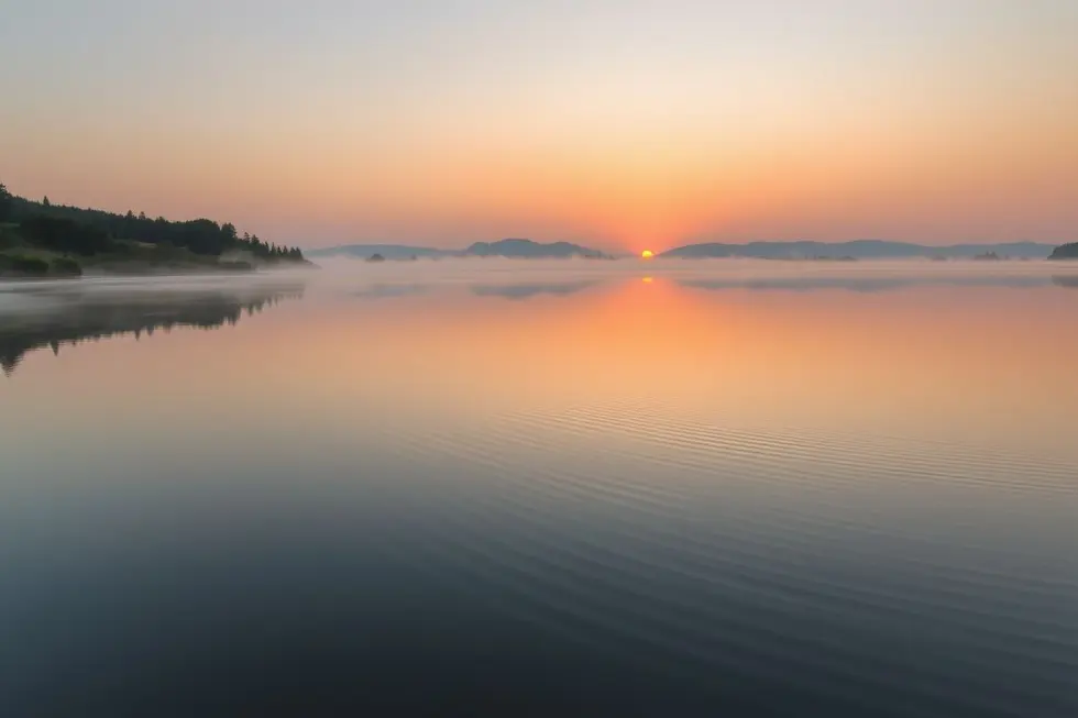 Paisagem tranquila de um lago ao amanhecer, simbolizando novos começos.